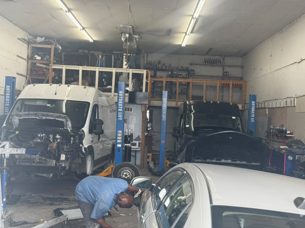 Service bays with vans and cars raised on hydraulic lifts