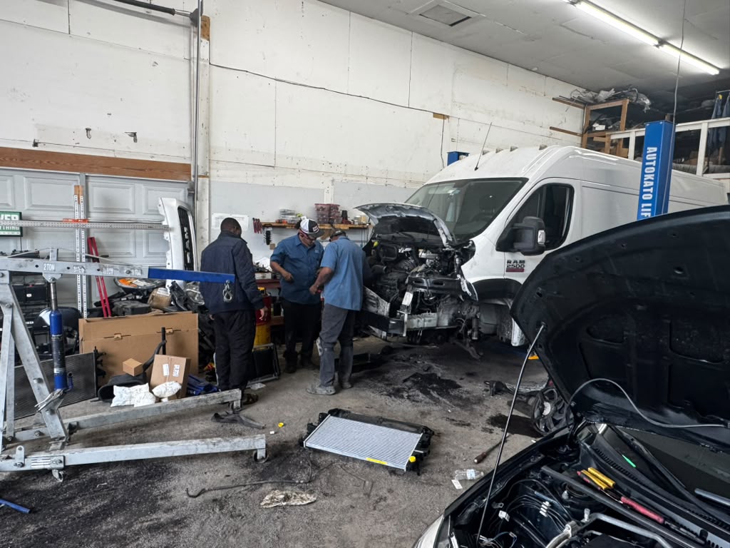 Three Eaglesoar technicians consulting around an open van engine bay